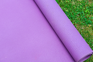 Image showing Fitness mat on the green grass background