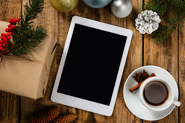 Image showing Mock up blank empty screen of tablet on wooden background