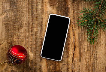 Image showing Mock up blank empty screen of smartphone on wooden background