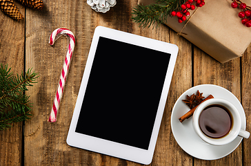 Image showing Mock up blank empty screen of tablet on wooden background