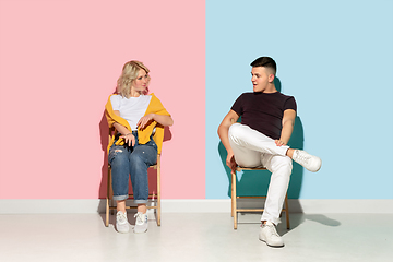 Image showing Young emotional man and woman on pink and blue background