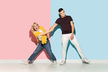 Image showing Young emotional man and woman on pink and blue background