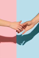 Image showing Female and male hands holding on pink and blue background