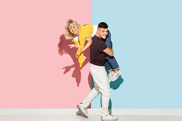 Image showing Young emotional man and woman on pink and blue background