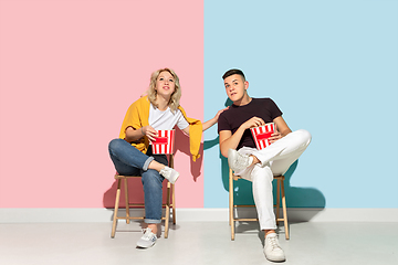 Image showing Young emotional man and woman on pink and blue background