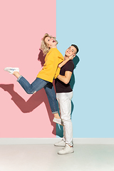 Image showing Young emotional man and woman on pink and blue background