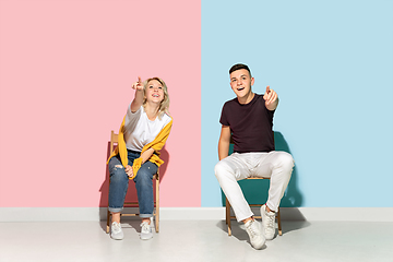 Image showing Young emotional man and woman on pink and blue background