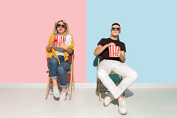 Image showing Young emotional man and woman on pink and blue background