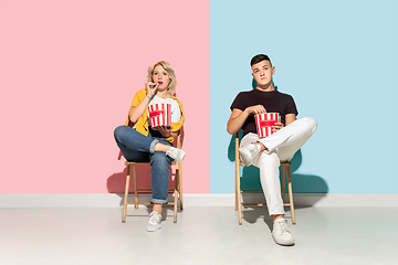 Image showing Young emotional man and woman on pink and blue background