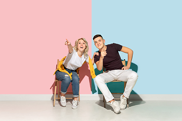 Image showing Young emotional man and woman on pink and blue background