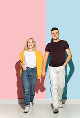 Image showing Young emotional man and woman on pink and blue background