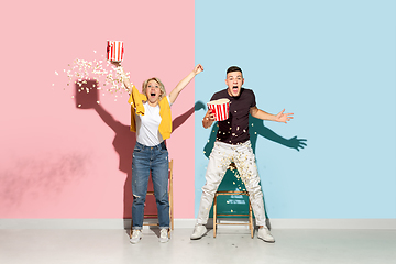 Image showing Young emotional man and woman on pink and blue background