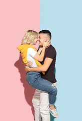 Image showing Young emotional man and woman on pink and blue background