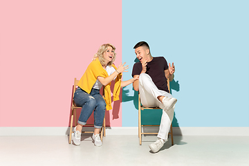 Image showing Young emotional man and woman on pink and blue background