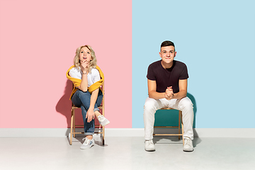 Image showing Young emotional man and woman on pink and blue background