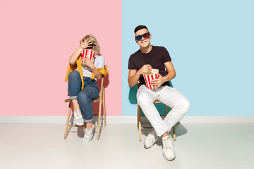 Image showing Young emotional man and woman on pink and blue background