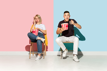 Image showing Young emotional man and woman on pink and blue background