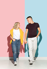 Image showing Young emotional man and woman on pink and blue background