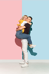 Image showing Young emotional man and woman on pink and blue background