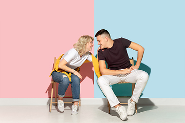 Image showing Young emotional man and woman on pink and blue background