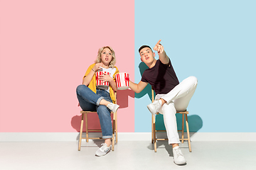 Image showing Young emotional man and woman on pink and blue background