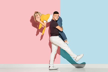 Image showing Young emotional man and woman on pink and blue background