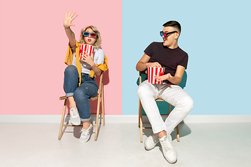 Image showing Young emotional man and woman on pink and blue background