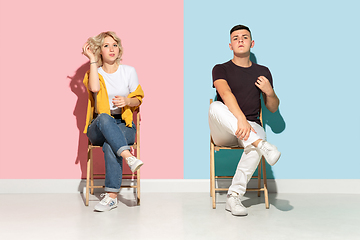 Image showing Young emotional man and woman on pink and blue background