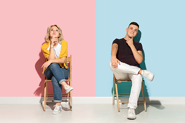 Image showing Young emotional man and woman on pink and blue background