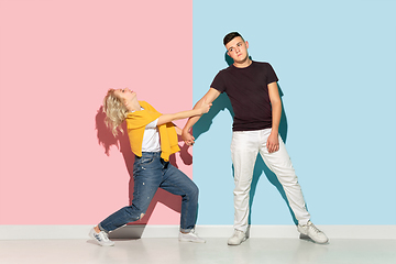 Image showing Young emotional man and woman on pink and blue background