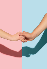 Image showing Female and male hands holding on pink and blue background