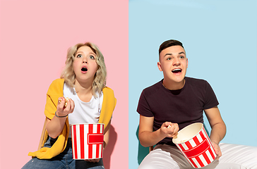 Image showing Young emotional man and woman on pink and blue background