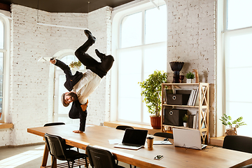 Image showing Businessman having fun dancing break dance in the office at work