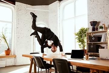 Image showing Businessman having fun dancing break dance in the office at work