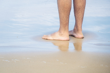 Image showing male bare feet in the wet sand