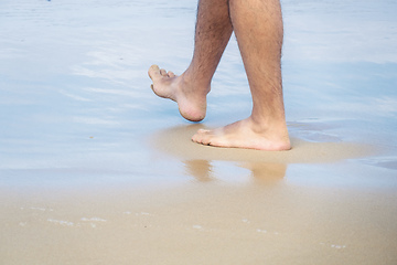 Image showing male bare feet in the wet sand