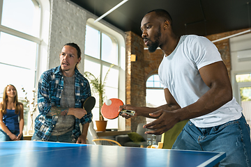 Image showing Young people playing table tennis in workplace, having fun