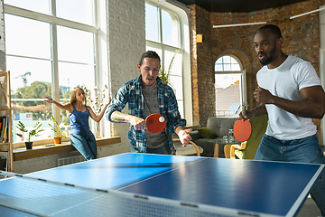 Image showing Young people playing table tennis in workplace, having fun