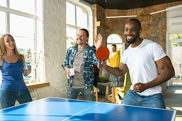 Image showing Young people playing table tennis in workplace, having fun