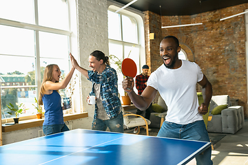 Image showing Young people playing table tennis in workplace, having fun