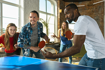 Image showing Young people playing table tennis in workplace, having fun