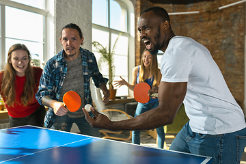 Image showing Young people playing table tennis in workplace, having fun