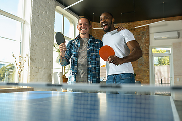 Image showing Young men playing table tennis in workplace, having fun