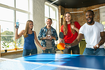 Image showing Young people playing table tennis in workplace, having fun