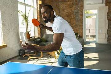 Image showing Young man playing table tennis in workplace, having fun