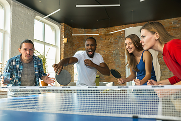 Image showing Young people playing table tennis in workplace, having fun