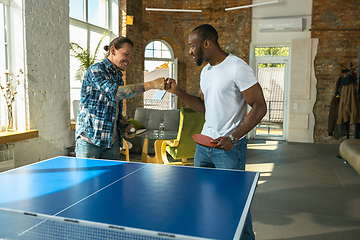 Image showing Young men playing table tennis in workplace, having fun