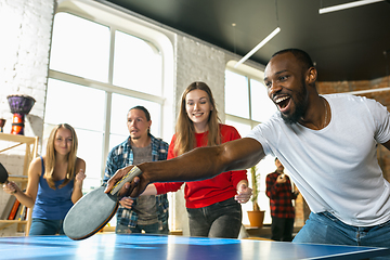 Image showing Young people playing table tennis in workplace, having fun