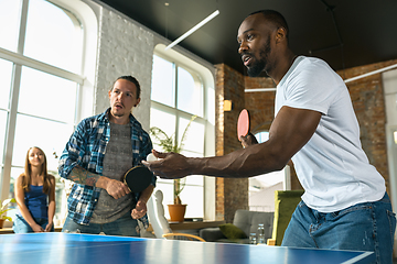 Image showing Young people playing table tennis in workplace, having fun