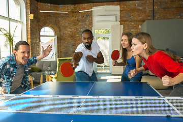 Image showing Young people playing table tennis in workplace, having fun